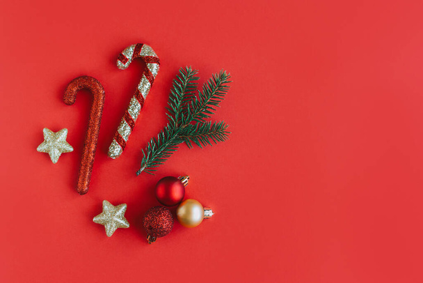 Ramo di abete rosso e ornamenti natalizi su sfondo rosso. Concetto vacanza. Posto per testo. - Foto, immagini