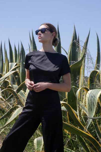 Outdoor mode portret van toeristische vrouw in zwarte zijde outfit tijdens de zomervakantie, lente zomer collectie, eenvoudige luxe stijl - Foto, afbeelding