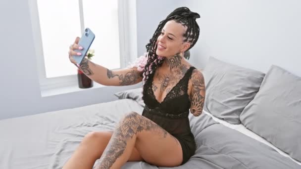 Itsevarma latino amputoitu nainen ottaa seksikäs selfie sängystä, istuu rento hänen viihtyisä makuuhuone, nauttia hänen älypuhelin valokuvaus - Materiaali, video