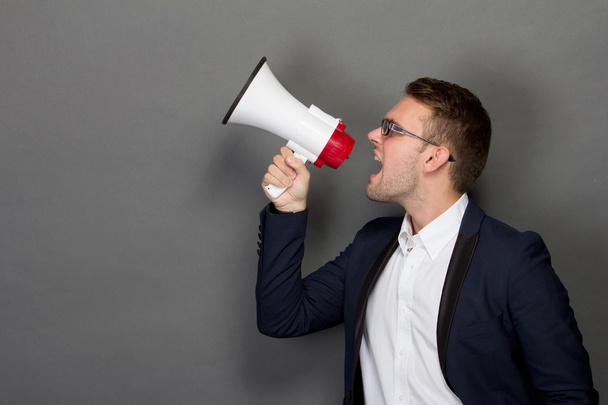 Young businessman with a megaphone - Foto, afbeelding