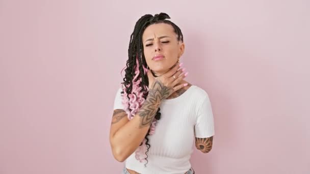 Latynoska kobieta po amputacji stoi nad odizolowanym różowym tłem, chwytając bolesną szyję w bólach grypy i bolesnej infekcji gardła - Materiał filmowy, wideo