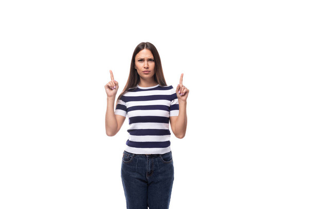junge schlanke Europäerin mit schwarzen glatten Haaren, die ein gestreiftes schwarz-weißes T-Shirt trägt, verkündet die Nachricht mit Gesten. - Foto, Bild