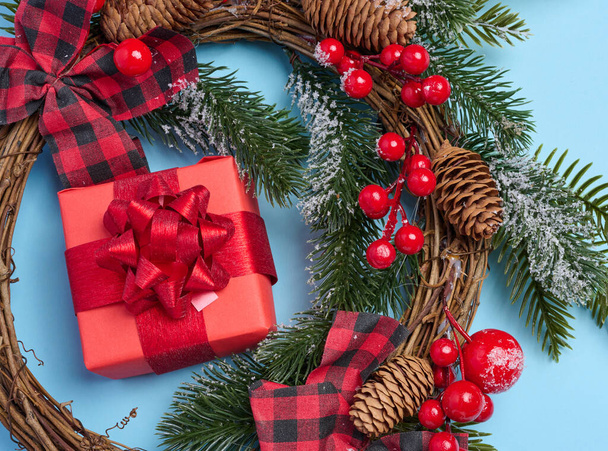 Χριστουγεννιάτικη διακόσμηση, δώρα τυλιγμένα σε κόκκινο χαρτί σε μπλε φόντο, top view.  - Φωτογραφία, εικόνα