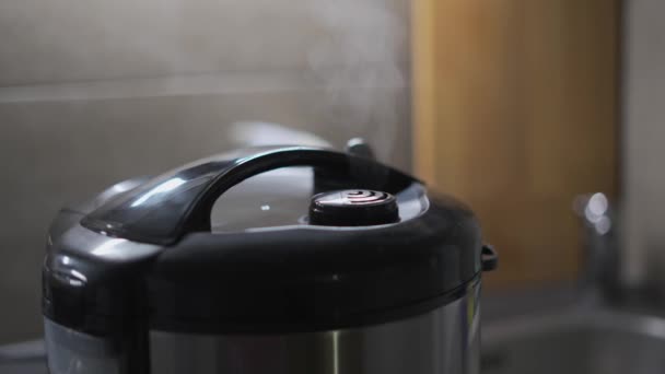 Close-up van stoom ontsnappen uit mondstuk van keuken multicooker tijdens het koken van voedsel in de keuken. Elektrische apparaten voor thuis en keuken. Automatische multi-fornuis, snelkookpan. Rijstmaker brouwen - Video