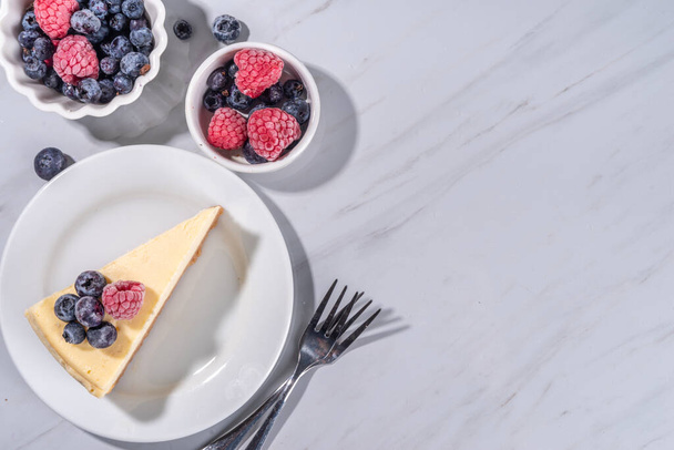 Частина сиру на тарілці, з малиною на чорниці на білому мармуровому фоні  - Фото, зображення