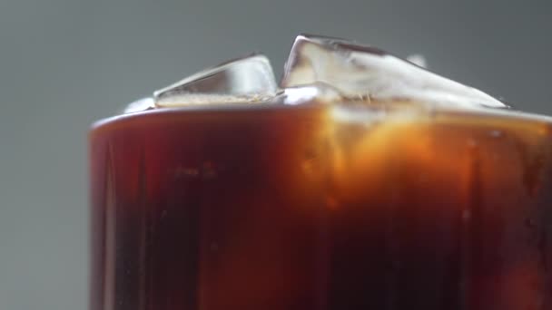 Langzame beweging en roteert iced Americano koffie in glas - Video