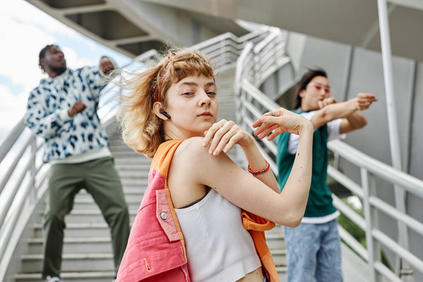 Různorodá skupina lidí na sobě barevné oblečení tančí venku v městském prostředí - Fotografie, Obrázek