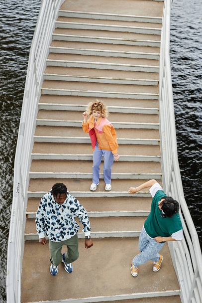 Vista superior gráfica del grupo de jóvenes que bailan en las escaleras al aire libre y usan ropa colorida de estilo callejero - Foto, imagen