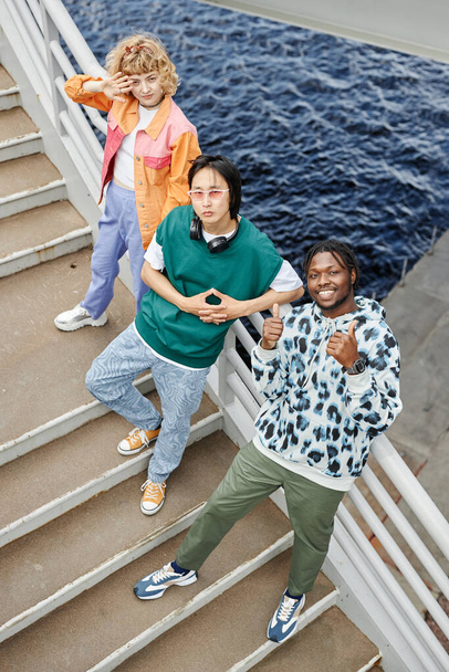 Grafické horní pohled na různé mladé lidi na schodech vzhlíží s vodou v pozadí - Fotografie, Obrázek