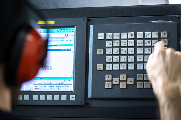 CNC operatörü, mekanik teknisyeni işçi metal işleme freze Merkezi aracı atölye gürültü kulaklık giyen klavye ile veri ekleme - Fotoğraf, Görsel