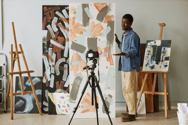 Молодий впевнений афроамериканський художник робить презентацію своєї колекції і вказує свою основну тему під час ефіру - Фото, зображення