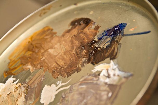 Gedämpfte Ölfarben auf einer Künstler-Palette - Kreative Farben warten auf ihre Leinwand, während sich ein versierter Künstler in Fort Wayne, Indiana, darauf vorbereitet, ihre Vision zum Leben zu erwecken. Hat satte Erdtöne und kontrastreiche - Foto, Bild