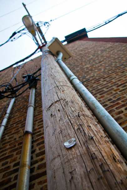 Infraestrutura urbana: Pólo de utilidade de madeira envelhecido com superfície intemperizada e acessórios, mostrando a interconexão de sistemas de utilidade urbana. Capturado em Chicago, Illinois. - Foto, Imagem