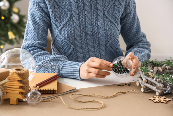 Mujer decorando la bola de Navidad con diamantes de imitación en la mesa - Foto, imagen