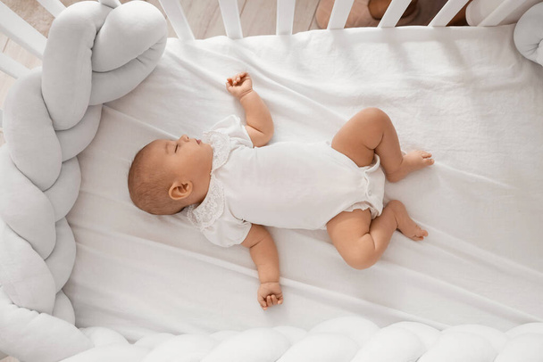 自宅でベビーベッドで寝ている小さなかわいい赤ちゃん - 写真・画像