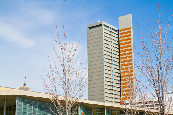 Moderno edificio de gran altura en el centro de Fort Wayne, Indiana, muestra una llamativa franja vertical naranja en medio de rayas horizontales blancas y grises. Estructura contemporánea de baja altura con paneles de vidrio - Foto, imagen
