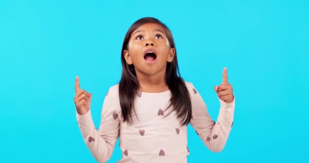 Stüdyodaki kız çocuğu mavi arka planda sürpriz bir duyuruyla ellerini havaya kaldırdı. Omg, haber ve çocuk sahibi şok, emoji ve açık ağızlı promosyon, anlaşma ya da yakında satış. - Video, Çekim