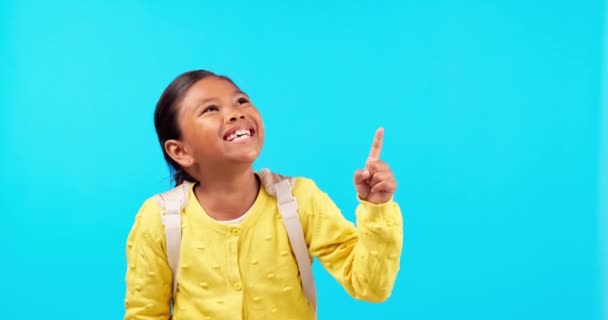 Nauraa, käsi osoittaa ja onnellinen tyttö lapsi studiossa takaisin koulun myyntiin, ilmoitus tai promo sinisellä taustalla. Hymyile, uutiset ja lapsi opiskelija päiväkoti käsitellä, tulossa pian tai info. - Materiaali, video