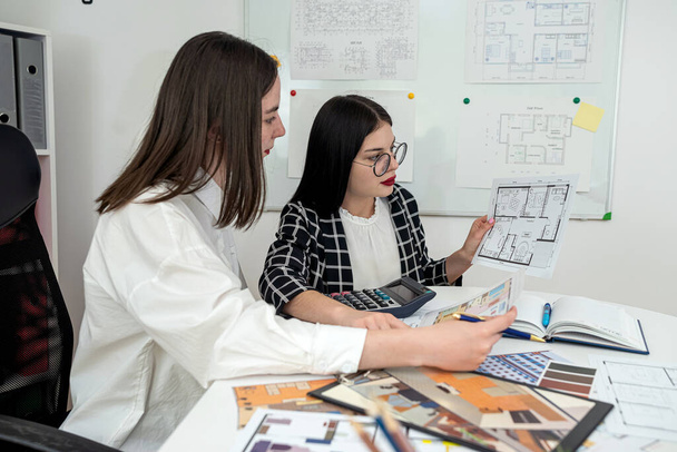 Deux femmes architectes travaillent ensemble sur le projet de construction de maisons et discutent au bureau. Travail d'équipe - Photo, image