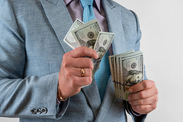 Junge Geschäftsleute zeigen Dollars in der Hand isoliert auf grau, Finanzen zählen - Foto, Bild