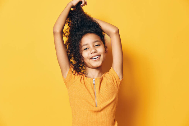 Nő lány fiatal vidám lány haj kis aranyos boldog modell szépség személy női háttér életmód háttér gyermekkor csinos portré mosoly sárga - Fotó, kép