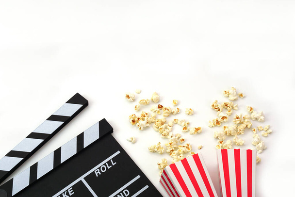 Clapperboard o film ardesia colore nero con popcorn su sfondo bianco. Industria cinematografica, produzione video e concetto di film. - Foto, immagini