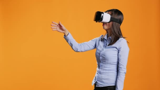 Asiatico donna opera realtà virtuale auricolare sulla macchina fotografica, godendo di intelligenza artificiale metaverso su occhiali moderni. Giovane che utilizza vr occhiali per la simulazione di tecnologia visiva in studio. - Filmati, video