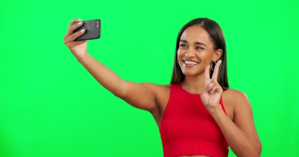 Vihreä ruutu, selfie ja nainen, jolla on rauhanmerkki, hymy ja sosiaalinen media studiotaustaa vasten. Nainen henkilö, malli ja tyttö onnea, muotia ja v ele ilolla, onnellinen ja iloinen. - Materiaali, video