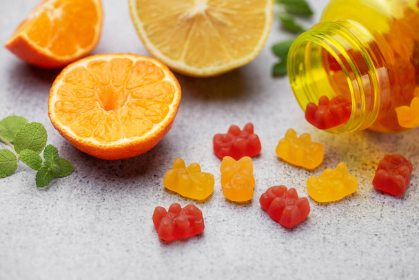 チューブ可能なガミーはビタミンとサプリメントと新鮮なオレンジを熊 - 写真・画像