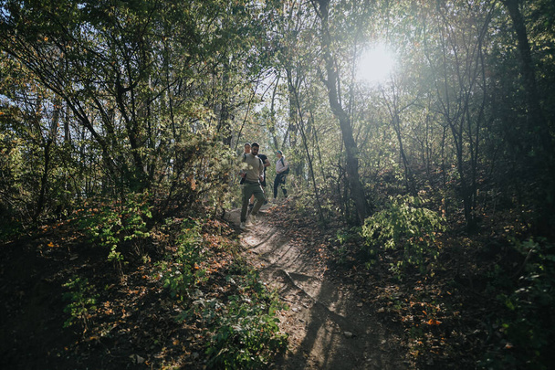 Gli amici sportivi si godono una giornata di sole passeggiando nella foresta, esplorando la natura e conversando. Un'avventura all'aria aperta perfetta per un weekend sano e divertente. - Foto, immagini