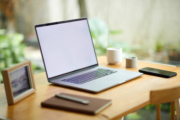 Laptop z białym ekranem na biurku przedsiębiorcy pracującego w domu - Zdjęcie, obraz