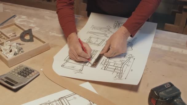 Περικοπή shot of hands of unrecognizable man drawing consrtuction drawing of wooden chair - Πλάνα, βίντεο