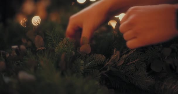 Mujer cortando ramas de abeto para hacer corona de Navidad para las vacaciones de Navidad. Decoraciones de Navidad, hacer decoraciones de la corona de Navidad. - Imágenes, Vídeo
