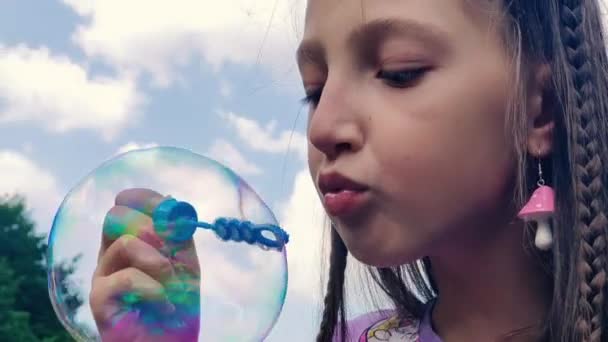 Holčička fouká mýdlové bublinky. dítě foukání mýdlové bubliny - Záběry, video