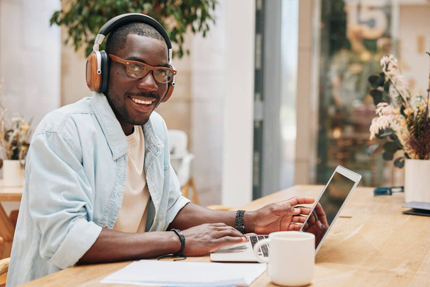 Tietokone mies liike kuuntelee toimisto kuulokkeet tekniikka mies verkossa afrikkalainen kannettava tietokone koulutus nuori opiskelija liikemies musiikki työskentelee kuulokkeet ammatillinen henkilö - Valokuva, kuva