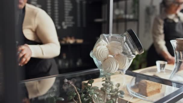 A kisvállalkozás női tulajdonosának szelektív fókusza a süteményeket és süteményeket bemutató bemutatóra - Felvétel, videó