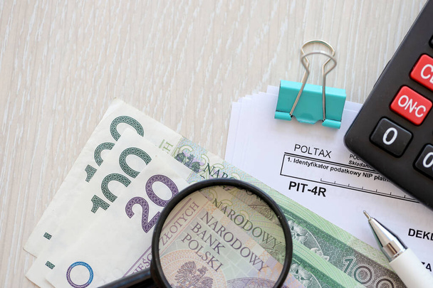 Річне декларування авансів податку на прибуток, форма ПІТ-4Р на бухгалтерській таблиці з ручкою та польськими купюрами злотих крупним планом - Фото, зображення