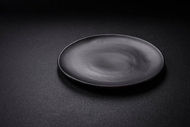 Placa de cerámica vacía en un fondo de hormigón texturizado. Artículo de utensilio de cocina - Foto, Imagen