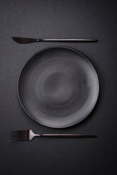 Bumpy empty ceramic plate on a textured concrete background. Kitchen utensil item - Photo, Image