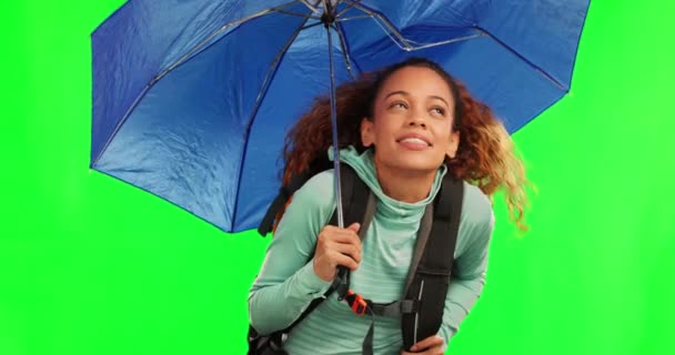 Young woman, umbrella and rain by green screen for travel, adventure and check sky with cover in mockup. Student girl, parasol and protection from winter weather with walking, journey and hiking. - Footage, Video
