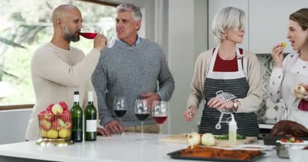 Οικογένεια, κουζίνα και μαγείρεμα με ποτήρι κρασιού για εορτασμούς διακοπών, Ευχαριστίες ή μιλώντας για μεσημεριανό γεύμα στο σπίτι. Ευτυχισμένοι ηλικιωμένοι, γονείς ή άνδρες και γυναίκες που βοηθούν με το φαγητό και το αλκοόλ για το νέο έτος. - Πλάνα, βίντεο