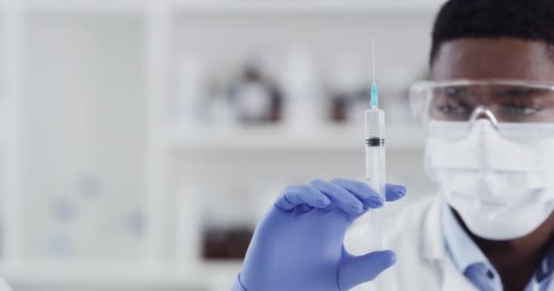 Science, vaccine and syringe with man in laboratory for experiment, solution and healthcare. Analysis, medical and medicine with African scientist and dna research for cure, chemistry and study. - Footage, Video