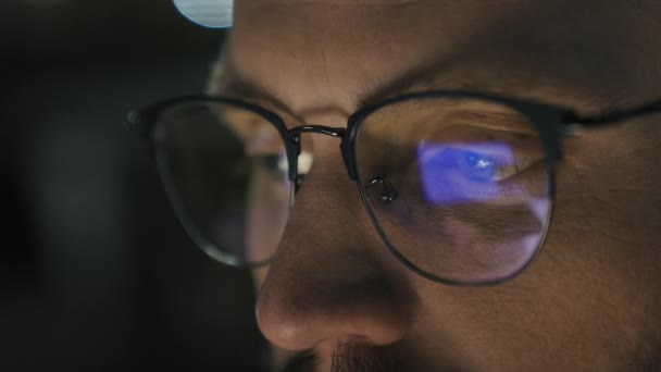Gros plan yeux masculins dans les lunettes tension oculaire problème médecine nuit sombre homme homme d'affaires développeur ordinateur programmeur homme d'affaires regardant écran bleu ordinateur portable affichage moniteur réflexion dans les lunettes - Séquence, vidéo