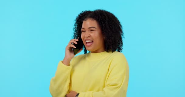 Feliz, llamada telefónica y reír con la mujer en el estudio para la comunicación, el contacto y la creación de redes. Tecnología, felicidad y conversación con la persona femenina en el fondo azul para la discusión y móvil. - Metraje, vídeo