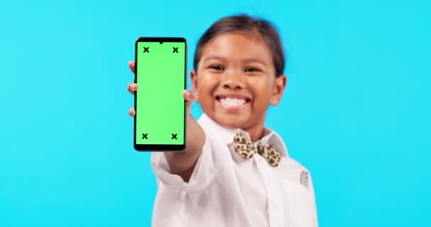 Κοριτσάκι, τηλέφωνο και mockup οθόνη για διαφήμιση ή μάρκετινγκ σε ένα μπλε φόντο στούντιο. Πορτρέτο του γυναικείου χαμόγελου παιδιού ή παιδιού με εφαρμογή smartphone, έγχρωμη οθόνη και δείκτες εντοπισμού. - Πλάνα, βίντεο