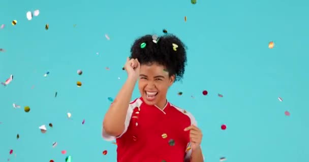 Confetti, celebrate and pointing woman excited for studio bonus, winning reward or prize giveaway. You celebration, birthday party success and portrait person gesture at winner on blue background. - Footage, Video