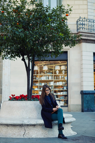 Businesswoman sitting outdoors - Фото, изображение