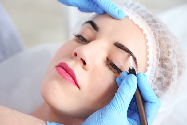 Cosmetologist applying permanent make up on eyebrows - Φωτογραφία, εικόνα