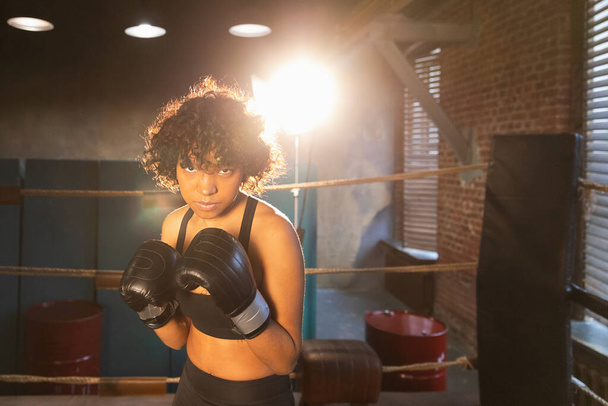 Huutakaa itsenäinen tyttövoima. Vihainen afrikkalainen amerikkalainen nainen taistelija nyrkkeilyhanskat näyttää vakava aggressiivinen seisoo nyrkkeily rengas. Vahva voimakas taistelija tyttö koulutus lyöntejä - Valokuva, kuva
