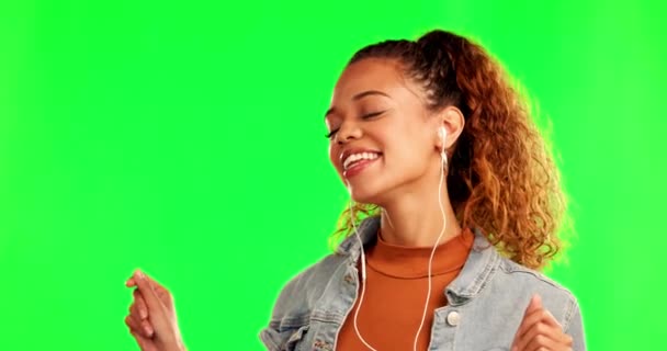 Happy woman, dancing and listening to music on green screen against a studio background. Female person with earphones enjoying audio, streaming or sound track for fun radio on chromakey mockup space. - Footage, Video